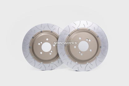 Two drilled and slotted brake rotors with a metallic silver outer ring and a tan center, featuring the 'Spectworks' logo on the front, set against a light gray background.